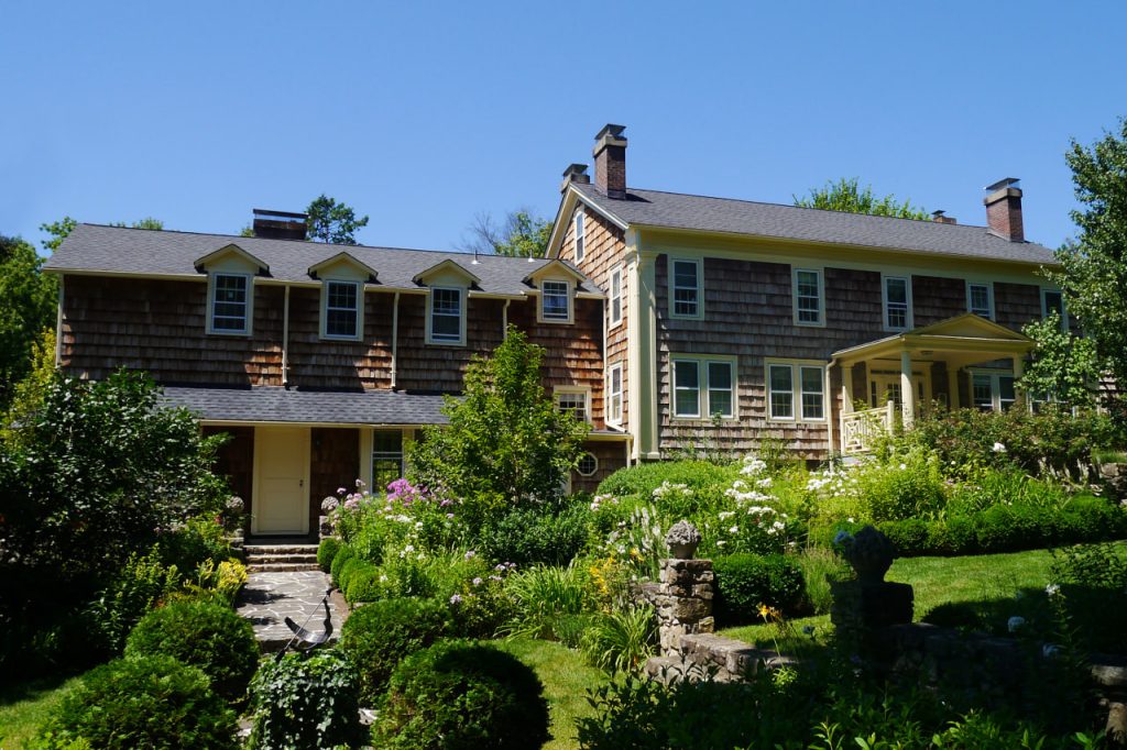 Rustic garden design with elevated stone patio, stone steps and stone footpaths around landscaped lower level of the backyard.